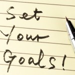 Set your goals words written on lined paper with a pen on it